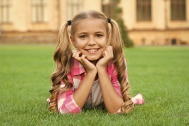 positive teen child portrait relax on green grass outdoor.