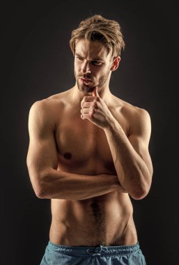 Kaslı kaslı yetişkin bir adam. Kaslı kaslı bir adamın fotoğrafı. Gri arka planda kaslı kaslı bir adam. Stüdyoda kaslı bir adam var..