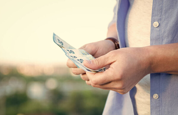 Гай вид на урожай, считая наличные деньги банкноты размываются на улице.