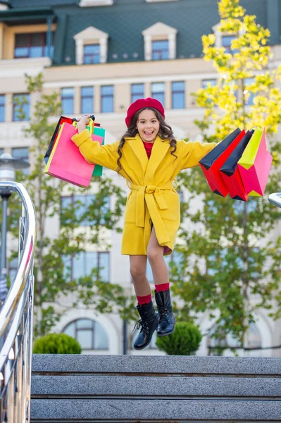 Alışveriş torbaları açık havada mutlu bir genç. Sonbahar montlu genç kız. Sonbahar alışverişçisi kız şehirde butikleri keşfediyor. Sonbahar alışverişçisi kız kıyafetlerini mevsimlik satışlarla değiştiriyor..