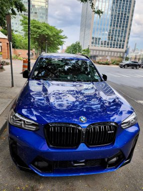 New York City, ABD - 09 Haziran 2023: BMW X3 M COMPETITION mavi SUV ön manzara park.