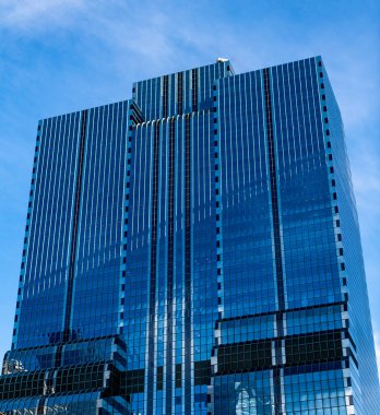 Gökdelen mimarisi. Camsı yüzlü bir gökdelen. Modern cam bina. Metropolis City 'de bir gökdelen. Şehir merkezinde gökdelenli bir şehir. İş bölgesinde çağdaş ofis binası.