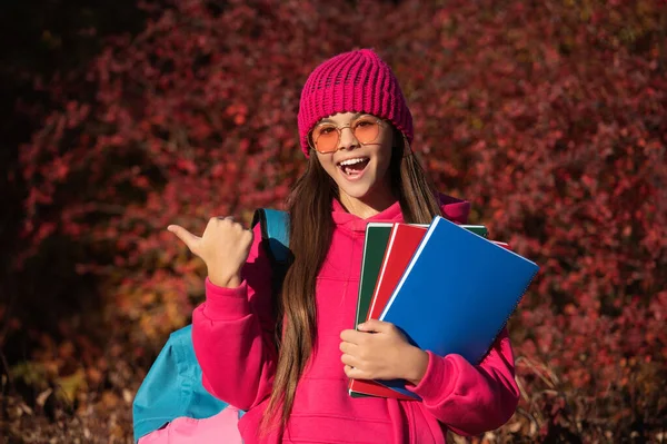 stock image autumn is a time to study. knowledge and education. school knowledge. back to school. amazed autumn girl point finger on school homework. knowledge for adolescence. teen girl in autumn park outdoor.