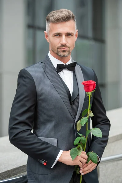 engagement concept. tuxedo man celebrate engagement. man with rose gift for engagement.
