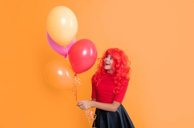 positive child with party balloon on yellow background.