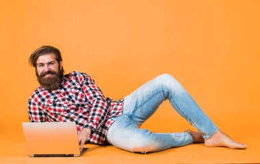 İşçi portresi. iş dünyasındaki modern teknoloji. Çevik iş. Dijital yaşam tarzı kavramı. Bilgisayarda çalışan olgun bir öğrenci. Adam defter üzerinde çalışıyor. İnternetten alışveriş. Neşeli hippi bilgisayar kullanıyor.