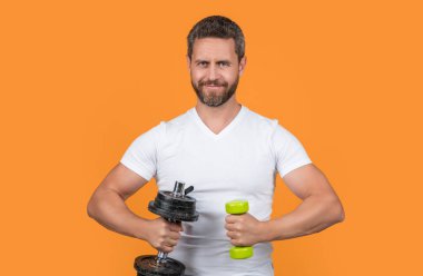 Stüdyoda dambılla güçlü bir spor antrenmanı yaparken gülümsüyordu. Dambılı tişörtlü güçlü bir sporcu eğitimi. Dambıllı güçlü bir sporcu eğitimi. Dambılı güçlü bir sporcu eğitimi.