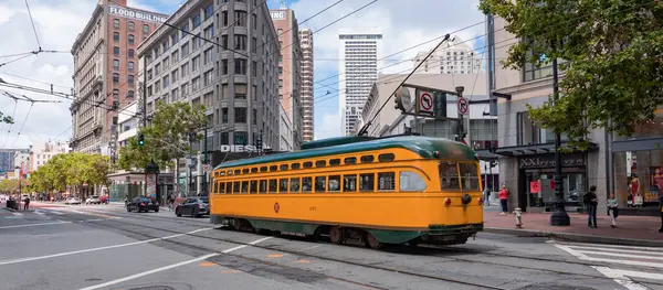 stock image San Francisco, USA - May 19, 2019: yellow sfmta tramcar public transport in the city street.
