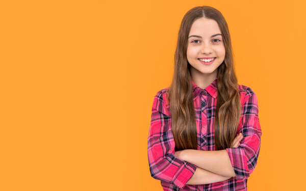 photo of teen girl with long hair wearing checkered shirt, copy space. teen girl isolated on yellow. teen girl in studio. teen girl on background.