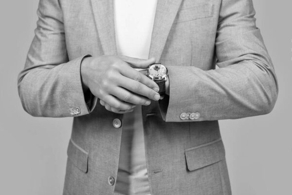 cropped view of man punctuality in studio. photo of handsome man follow punctuality with watch. man wearing watch. punctuality of man with watch in jacket isolated on yellow.