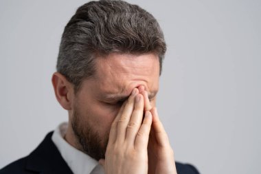 Yorgun adam baş ağrısından muzdarip. İş sorunları. Baş ağrısı migreni. Migreni olan takım elbiseli bir iş adamı. İş adamının ağrısı yüzünden migreni tuttu. İş Kaygısı.