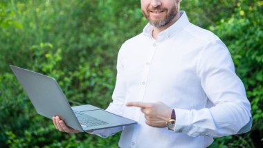 İş adamının fotoğrafında internet işi, işaret parmağı var. İş adamının internet işi var. İş adamlarının dışarıda online işleri var. İş adamının bilgisayarda internet işi var.