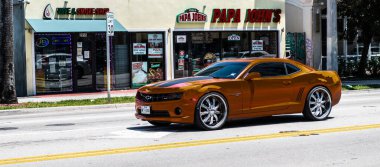 Miami Beach, Florida USA - April 15, 2021: orange Chevrolet Camaro SS 2019 muscle car, side view.