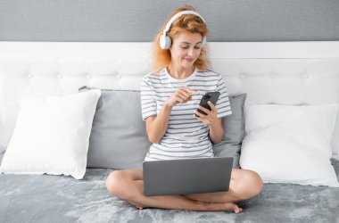Telefonda gülümseyen kadın sohbeti. Evde telefonla konuşan bir kadın. Kulaklıklı kadının telefon görüşmesi..