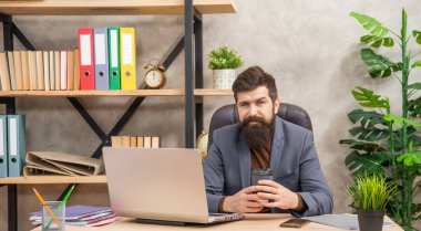 positive confident mature man freelancer use online computer communication at office holding coffee, modern life.