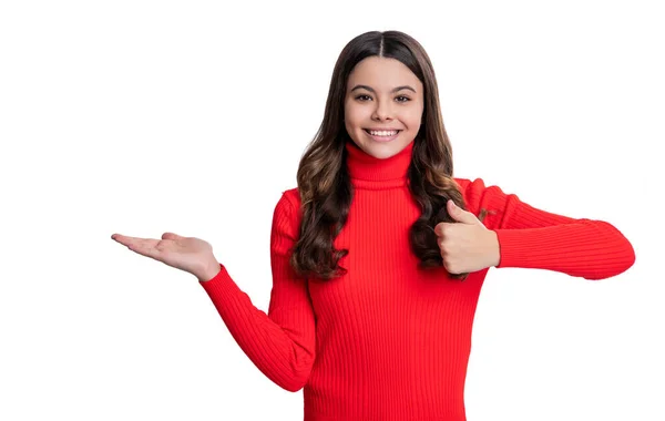 stock image teen girl directing to advertisement. teen girl presenting product with hand. teen girl presenting product on copy space. teen girl show advertisement. here is your advertisement. thumb up.