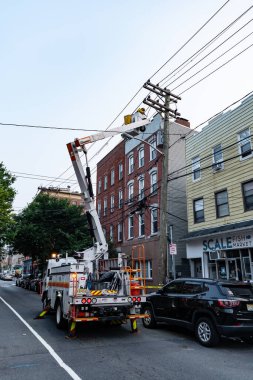 Jersey City, ABD - 30 Haziran 2023: Halat tamircileri elektrik hattı kova kamyonunda çalışıyor.