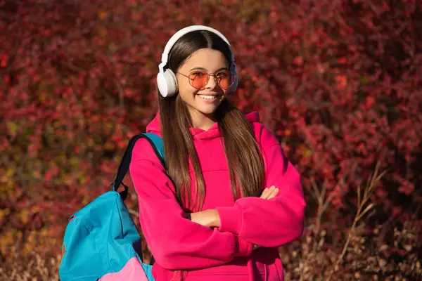 stock image student schoolgirl with backpack going to school wearing sunglasses and headphones. back to school. education and knowledge. autumn is a school time. school girl in autumn. teen education.