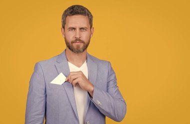 Adamın elinde boş bir kredi kartı var. Sarı kart izole edilmiş. Kredi kartı ve fotokopi alanı olan bir adam. Stüdyoda kredi kartı tutan bir adam var. Ceketli adamın kredi kartı var..