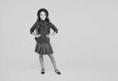 Bilgi günü. Eğitim konsepti. Sarı arka planda üniformalı bir çocuk. 1 Eylül. Mutlu çocukluk. Okul çantalı çocuk. kopyalama alanı. Sırt çantalı gülümseyen genç kız. Okula geri dön..