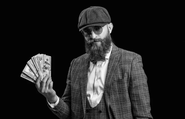 rich retro man with money isolated on black. rich retro man with money in studio. rich retro man with money on background. photo of rich retro man with money wear peaked cap.