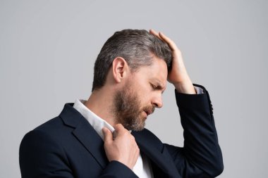 Yorgun adam baş ağrısından muzdarip. İş sorunları. Baş ağrısı migreni. Migreni olan takım elbiseli bir iş adamı. İş adamının ağrısı yüzünden migreni tuttu. hüsran.