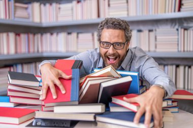 Derste ya da sınavda kitap kurdu öğretmeni. Kütüphanede kitap seven bir adam. Sınıfta öğretmen beyin fırtınası yapıyor. Eğitim yoluyla potansiyel. Öğretmen için bilgi günü. okul eğitimi ve bilgisi.