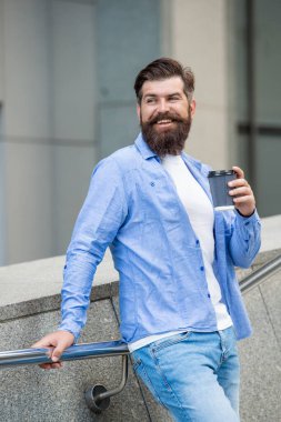 Sabah kahvesi içen pozitif bir adam. Dışarıda sabah kahveli bir adam var. Sokakta sabah kahvesi içen adam. Sabah kahveli bir adamın fotoğrafı..