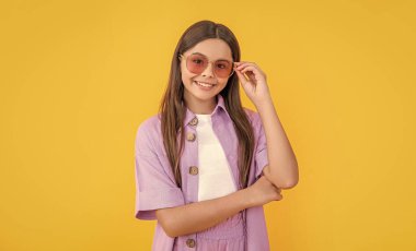 cheerful teenager girl in studio. teenager girl on background. photo of teenager girl with long hair wearing shirt. teenager girl isolated on yellow.