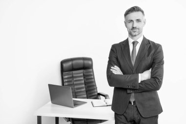 Yetişkin girişimci beyaz arka planda patron ofisinde takım elbise giyer..