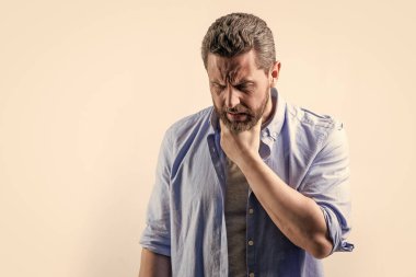 Ağrısı olan olgun bir adamın ağrısı. Gri üzerine izole edilmiş fotokopi uzayı. Stüdyoda boğazı ağrıyan bir adam var. Acı çeken ya da acı çeken bir adamın fotoğrafı. Ağrı çeken adam acı hisseder..