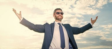 Gökyüzü arka planında başarılı bir iş adamı. Takım elbiseli başarılı bir iş adamı. Takım elbiseli başarılı bir iş adamı. Takım elbiseli başarılı bir iş adamının fotoğrafı..