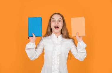 Şaşırmış genç kız, sarı arka plan ve eğitim üzerine ders kitabı sunuyor..