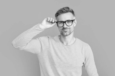 smiling man look in eyewear at studio. man look in eyewear on background. photo of man look in eyewear. man look in eyewear isolated on blue.