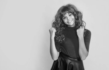 Sarı arka planda kızıl uzun saçlı mutlu çocuk..