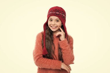 Sıcak şapka örgüsü. Güzel şapkalı genç kız modeli. Sıcak şapkalı genç kız beyaz arka planda izole edilmiş. Genç kız stüdyoda süveter ve kalın bir şapka giyer. Genç kızlar için kış modası.