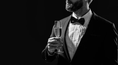 Smokinci stüdyoda fotokopi odasıyla tezahürat yapıyor. Smokinli adam şampanyayla tezahürat yapıyor. Amigo smokinli adamın fotoğrafı. Smokinli adam, siyah arka planda tek başına tezahürat yapıyor..