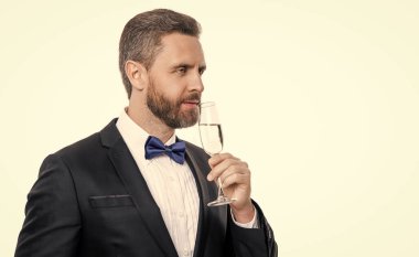 Şerefe ve kutlayalım. Smokinli adam stüdyoda kutlama yapıyor. Smokinli adam tezahürat ve kutlama için. Smokinli adam şampanya alır. Smokinli adam beyaz arka planda kutluyor ve kutluyor..