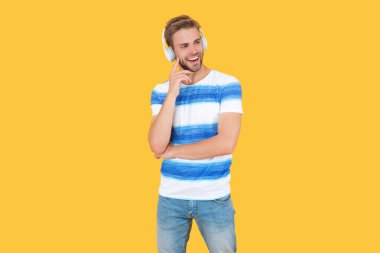 Mutlu adam çevrimiçi olarak stüdyoda ders alıyor. Esmer adam sarı arka planda izole edilmiş kulaklıklar kullanıyor. Genç adam çevrimiçi bir konferansa katılıyor. Kulaklık takan yapılı bir adam..