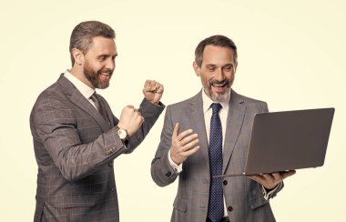 Stüdyoda serbest çalışan iş adamları. İş adamlarının dizüstü bilgisayarda serbest çalışırkenki fotoğrafı. İki iş adamı dizüstü bilgisayar kullanıyor. Beyaz arka planda serbest çalışan işadamları izole edildi.