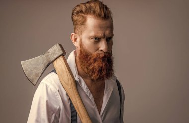 Baltalı, sakallı, erkeksi bir adamın fotoğrafı. Baltası gri renkte olan erkeksi bir adam. Stüdyoda baltası olan erkeksi bir adam. Arka planda balta olan erkeksi bir adam..