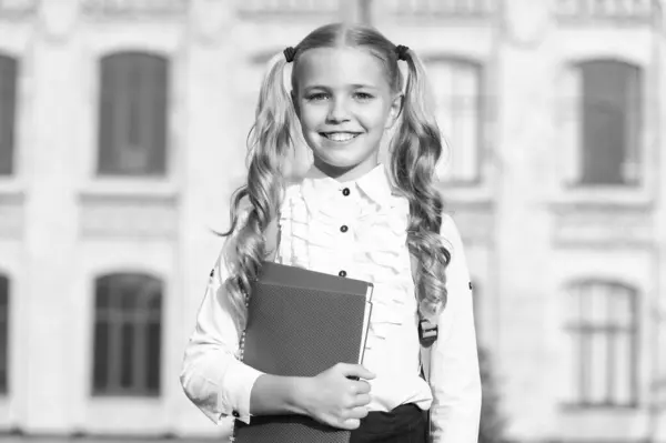 制服を着たピグテールを持つ幸せな十代の女の子は 屋外で学校の本を保持 学校に戻る — ストック写真