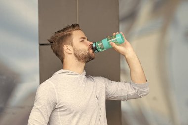Eğitimden sonra şişeden su içen susamış sporcunun fotoğrafı. Susamış sporcu. Susamış bir sporcu ve su şişesi. Susamış sporcu, dışarıda su var..
