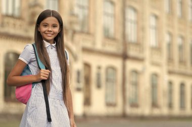 Neşeli liseli kız. Sırt çantalı liseli kız. Açık havada liseli bir kız. Genç bir kızın fotoğrafı, kopyalama alanı.
