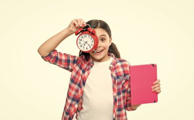 Çalar saati olan liseli kız, ürününü sunuyor. Arka planda çalar saati olan liseli kız. Çalar saati ve ödevi olan liseli bir kızın fotoğrafı. Alarmlı saati olan liseli kız beyaza izole edilmiş..