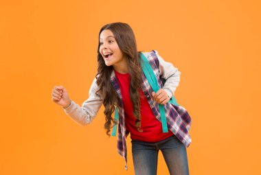 Mutlu bir okul çocuğu elinde bir şey tutuyormuş gibi davran. Sarı arka plan, reklam..