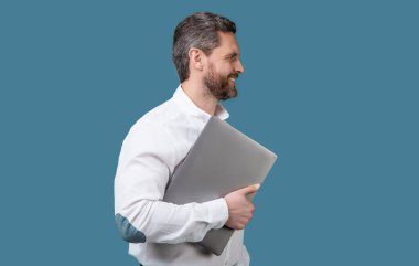 smiling businessman freelance with computer. businessman freelance holding laptop. businessman freelance isolated on blue background. businessman freelance in studio.
