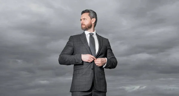 adult man in business suit. photo of man in suit. man in suit on sky background. man in suit outdoor.