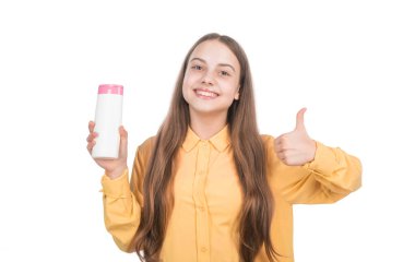 Mutlu genç kız şampuan ya da saç kremi şişesi sunuyor. Beyazlara izole edilmiş. Baş parmak yukarı, kişisel bakım..