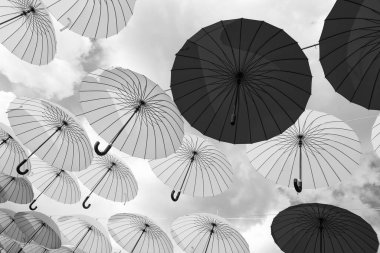 Bright color decorative umbrellas hanging bottom-up sky background.